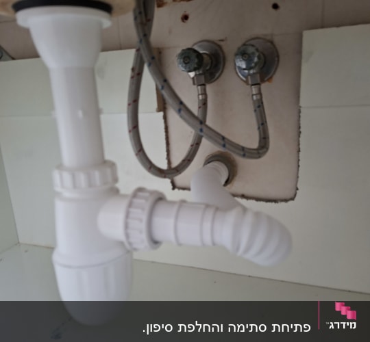 צנרת מתחת לכיור עם חיבורים וצינורות
